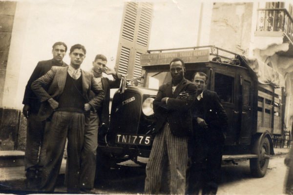 Όλα άρχισαν με δύο φορτηγά. Στη φωτογραφία ο Νίκος Λευκαρίτης (ο πρώτος μπροστά από αριστερά με τα χέρια στη μέση)
με το φορτηγό του.